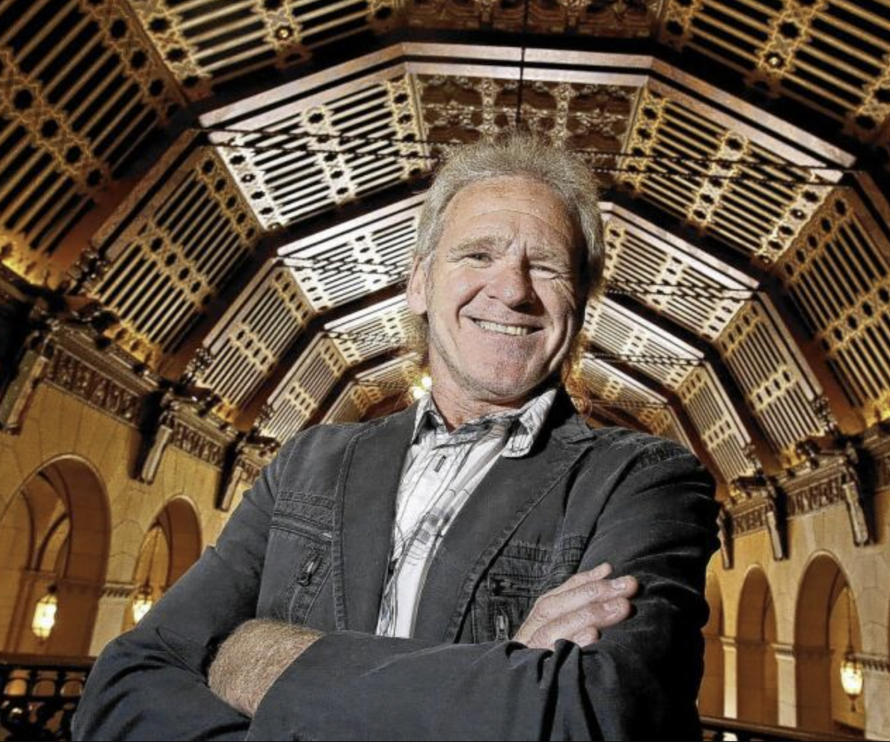 Ray Adamyk standing beneath the ornate ceiling of a historic building